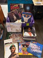 Top-down view of tote filled with vinyl records and some albums spread out around it revealing artists and covers.