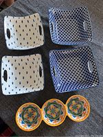 Four square porcelain dishes - two white with blue tree pattern, two blue with white net pattern, all with handles