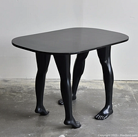 Front three-quarter view of entire table showing tabletop shape and four leg supports