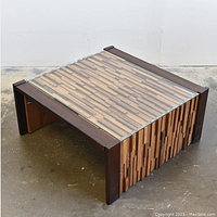 Table assembled with glass top, showing dark rosewood frame and wood mosaic surface