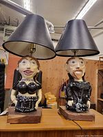 Pair of biker couple art lamps with vinyl leatherette black shades on wooden bases, approximately 32 inches tall