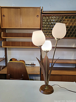 Lamp on white tabletop against mid-century modern shelving, showing full lamp