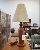 Full view of vintage Danish teak table lamp showing hourglass base and linen shade on table