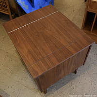Top view of vintage walnut finish side table showing hinged top surface with visible wood grain and clean edges.