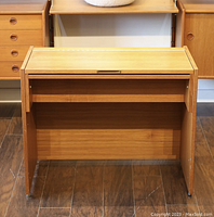 Front view of teak vanity desk with lid closed, showing clean lines and natural wood grain.