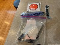 Photo of replacement main brush, side brush, and owner's manual for Bob Sweep robot vacuum on a countertop