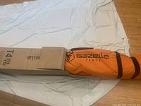 Orange zippered tent carrying bag with Gazelle Tents logo and black straps
