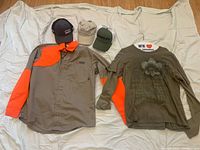 Lot laid out on a white fabric background showing all items in the lot: two shirts and three baseball caps.