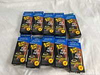 Ten boxed packs of Black Flag Fly Paper strips arranged on a cloth surface, showing front packaging details with brand and product name visible.