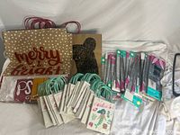 Photo showing jumbo gift bags with 'Merry & Bright' text, animal face design on kraft paper, small colorful Easter treat bags with handles, and several packaged items.