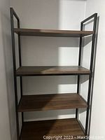 Front view of 5-shelf ladder bookcase showing wooden shelves and metal frame.