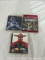 Three PlayStation 3 game cases placed on white fabric showing front covers for Star Wars: The Force Unleashed, inFAMOUS, and Spider-Man: Web of Shadows.
