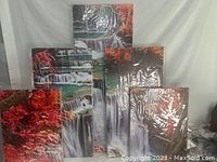 Set of five canvas panels showing a red waterfall surrounded by maple trees in fall colors, wrapped in plastic.
