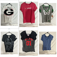 Front view of 6 short sleeved shirts on hangers showing graphics, prints and colors including sports logos.