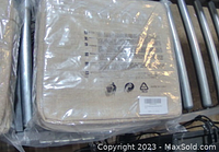 Three beige fabric storage bins still in plastic packaging stacked together, showing texture and label areas