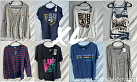 Front view of 8 women's tops on hangers, showing various styles and colors including shirts and sweaters, size XL.