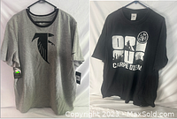 Photo of two men's graphic t-shirts, one gray with black abstract bird logo and one black with white '08 Carpe Diem' text and design