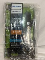 Front view of Philips Norelco Multigroom 7000 All-in-One Stainless Steel Groomer in unopened packaging showing branding, product, and features.