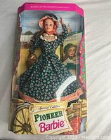 Front view of the Barbie doll in original packaging showing doll in green floral pioneer dress and bonnet, labeled Special Edition Pioneer Barbie from American Stories Collection.