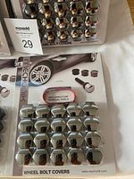 Four packets of Mechunk brand wheel bolt covers in chrome finish, each pack containing 12 covers and removal tools.