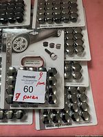 Nine packs of chrome wheel bolt covers arranged with front visible packaging showing the covers and included removal tools.