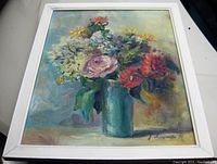 Frontal view of the signed oil painting showing the flower arrangement and white wood frame.