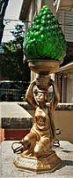 Frontal view of bronzed metal lamp base with kneeling lady and green grape glass shade