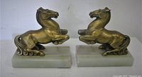 Front view of both gilt metal horse bookends on marble bases