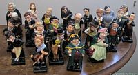 Group shot of all 24 figurines arranged on round table, front view.