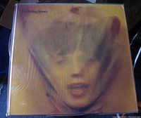Front cover of The Rolling Stones 'Goat's Head Soup' album showcasing artwork with blurred face in yellow tones.