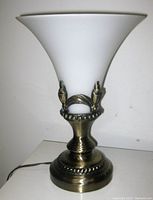 White frosted art glass lamp with metal antique brass base shown from front on white background.