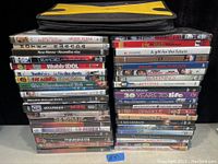 View of stacked DVD movies, showing titles and condition.