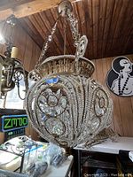Front view of the large ornate ceiling light fixture showing gold-tone metal frame with crystal bead decoration and large crystal orbs.