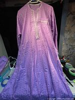 Full length photo of purple Nigerian traditional top showing fabric texture and embroidered details.