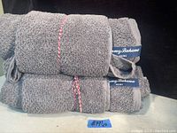 Four gray Tommy Bahama towels stacked, showing size difference between bath and hand towels