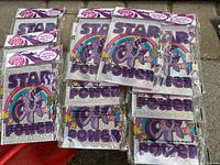 Top view showing all 10 individually packaged My Little Pony metallic diaries with lock. Covers display 'Star Power' and a pony character with rainbow and stars.