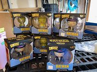 Photo showing six boxed Dorbz Batman figures including Batman, Penguin, and others, displayed in a group with visible packaging and character names.