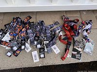 Photo showing a pile of 46 wrist lanyard bracelets and 4 neck lanyards with tags, displaying designs from Deadpool, Tokyo Ghoul, and Arise.