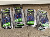 Bundles of the arcade game cabinet shaped notepads, packaged in plastic and stacked on the ground.