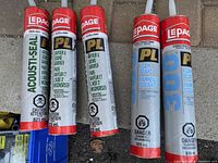 Five large tubes of Lepage brand adhesives and sealants including Acoust-Seal, Vapour & Sound Barrier, and Foam Board types with red caps and white nozzles.