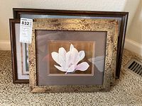 Four framed artworks stacked against a wall on carpeted floor, showing the original oil painting in distressed gold-tone frame in front and other framed prints behind.