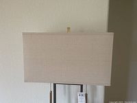 Top front view of floor lamp fabric shade showing beige rectangular design and metal support pieces on top inside of shade