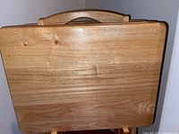 Close-up photo of one solid oak TV tray showing natural wood grain and built-in handle
