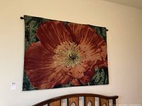 Full view of the red poppy tapestry hanging above a wooden bed headboard showing size and wall placement.