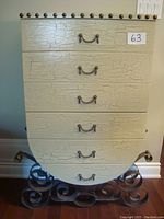 Front profile of the cabinet showing the six drawers with crackle finish and metal handle pulls. Decorative brass or bronze studs line the top and sides.