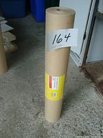 Full roll of kraft wrapping paper standing upright, labeled '164'.