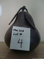 Front view of large pear sculpture with note indicating lot number