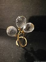 Three clear faceted crystal balloons on a gold-tone twisted metal stem forming a circular base, 2 inches tall.
