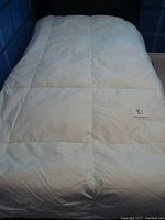 Full view of the white twin duvet laid on a bed showing quilted square pattern and overall good condition