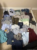Overview of 29 assorted men's shirts in size Large including various patterns such as checks, stripes, solids, and plaids in multiple colors.
